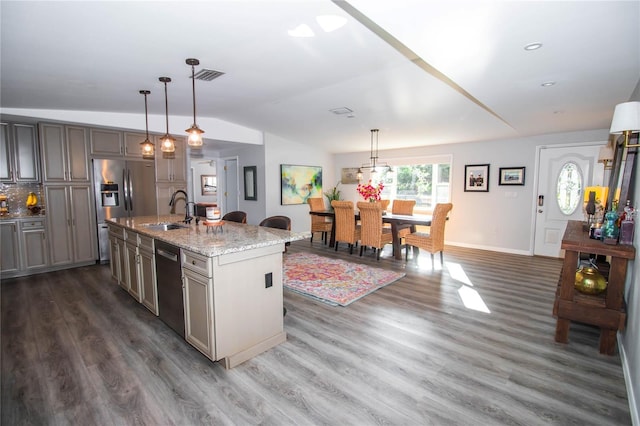 kitchen featuring appliances with stainless steel finishes, a sink, dark wood finished floors, vaulted ceiling, and visible vents