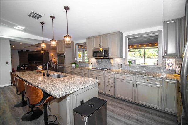 kitchen featuring backsplash, appliances with stainless steel finishes, a sink, and visible vents