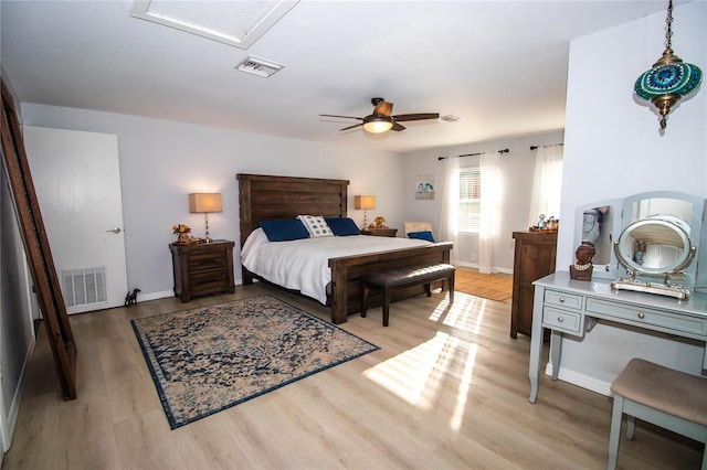 bedroom featuring visible vents, attic access, light wood finished floors, and baseboards