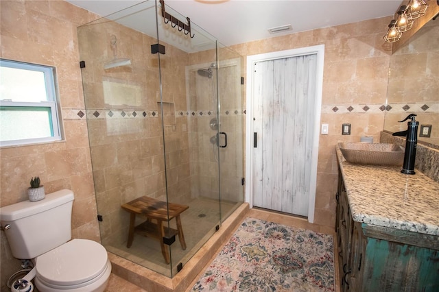 full bathroom with visible vents, a shower stall, toilet, and tile walls