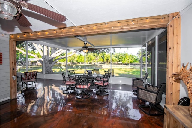 sunroom / solarium featuring a healthy amount of sunlight and ceiling fan