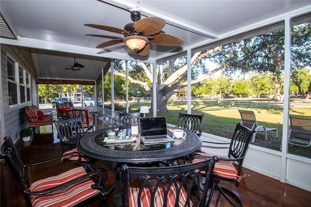 sunroom / solarium featuring a ceiling fan and outdoor dining area