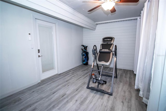 exercise room with baseboards, ceiling fan, and wood finished floors