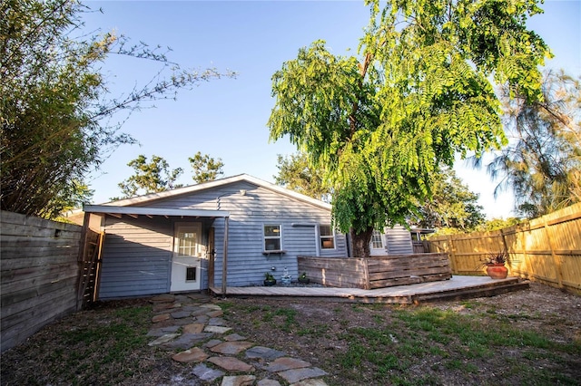 back of house with a fenced backyard and a deck