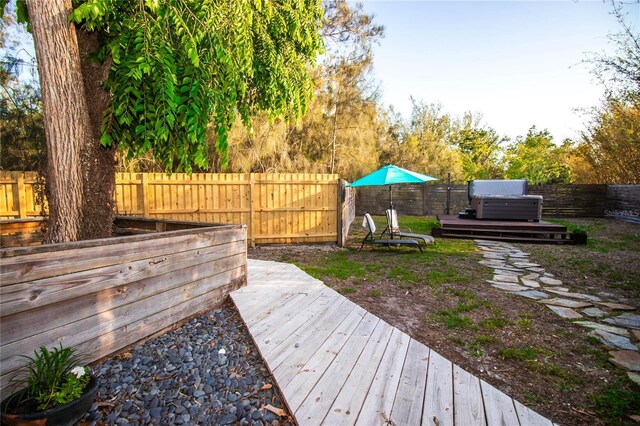 view of yard with a fenced backyard, a hot tub, and a wooden deck