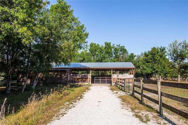 view of property's community with an outbuilding, an exterior structure, driveway, and a carport