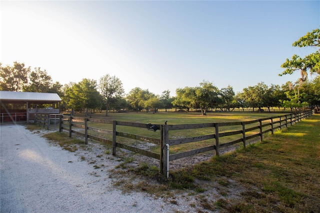 view of yard with an exterior structure, a rural view, and an outbuilding