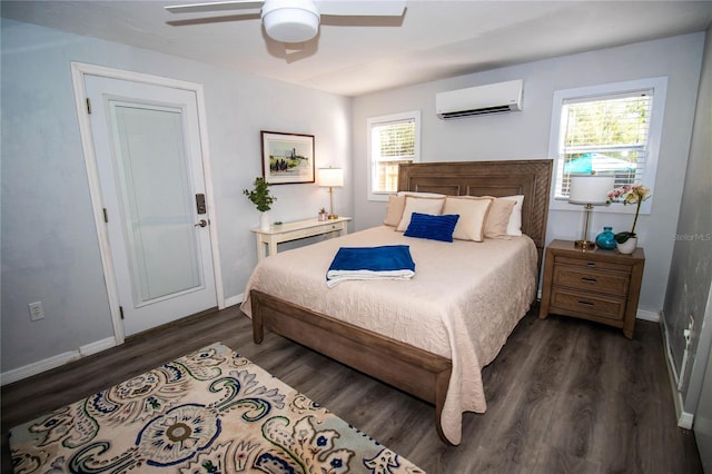 bedroom with a ceiling fan, baseboards, dark wood-type flooring, and a wall mounted air conditioner