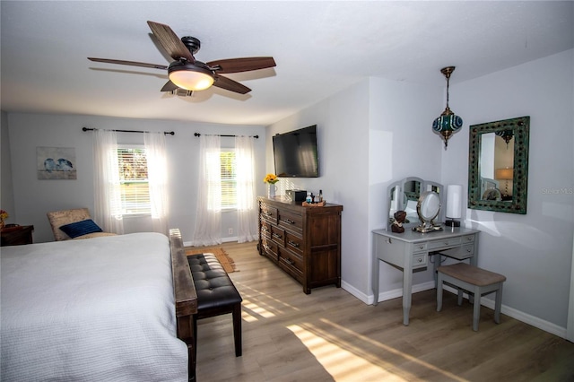 bedroom featuring a ceiling fan, baseboards, and light wood-type flooring