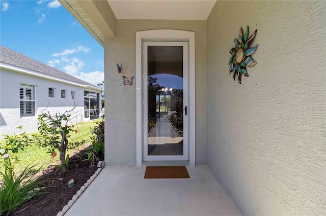 view of exterior entry featuring stucco siding