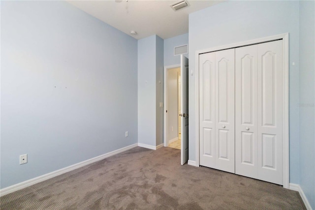 unfurnished bedroom with a closet, baseboards, carpet flooring, and visible vents