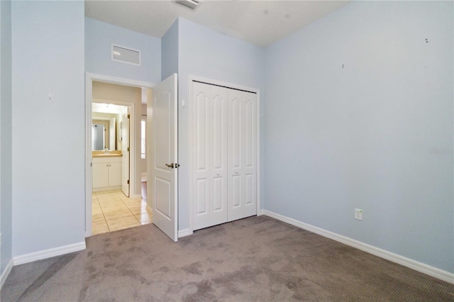 unfurnished bedroom with carpet floors, baseboards, a closet, and visible vents