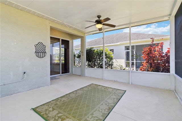 unfurnished sunroom featuring ceiling fan