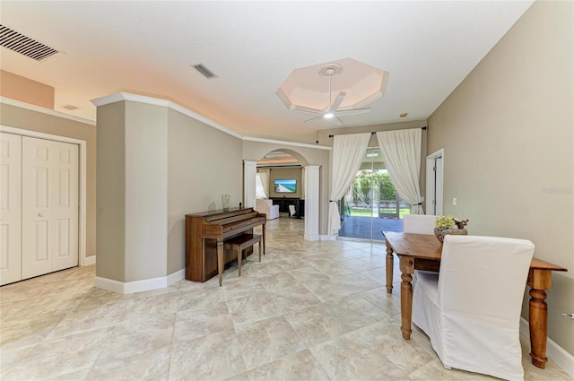 dining space with visible vents, arched walkways, baseboards, and a ceiling fan