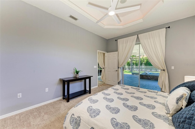 bedroom with light colored carpet, a raised ceiling, access to exterior, baseboards, and visible vents