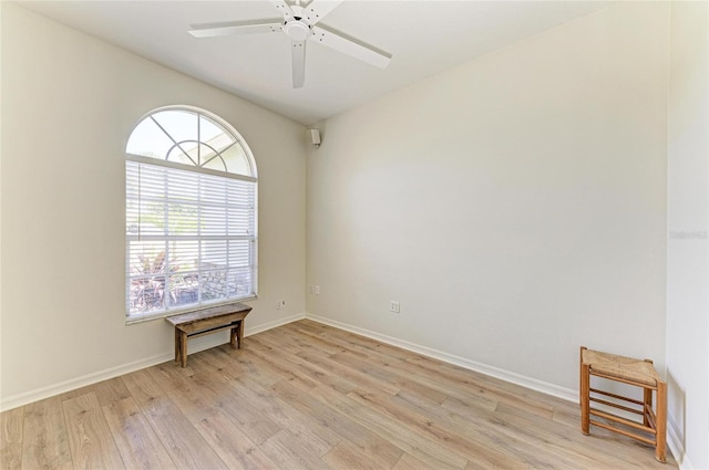 unfurnished room with baseboards, ceiling fan, and light wood finished floors