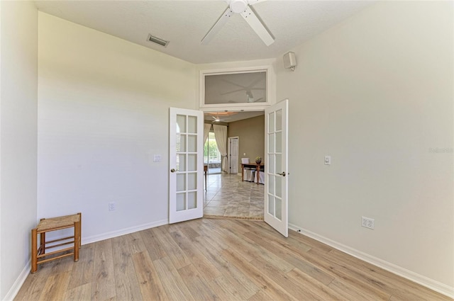 unfurnished room with french doors, light wood-style flooring, and visible vents
