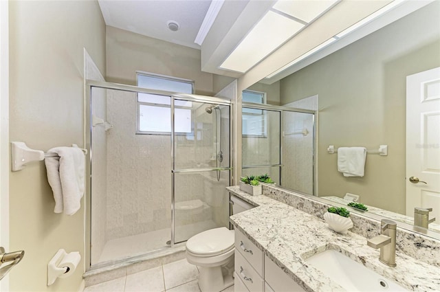 bathroom with vanity, tile patterned flooring, a stall shower, and toilet