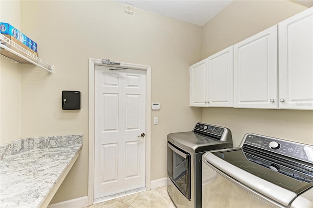 washroom featuring baseboards, washer and clothes dryer, cabinet space, and light tile patterned flooring