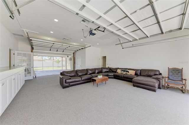 living area with carpet floors, a garage, recessed lighting, and visible vents