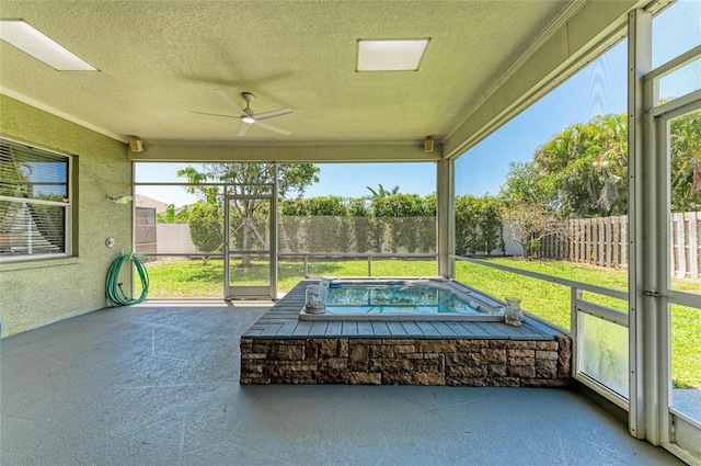 unfurnished sunroom with a ceiling fan and a healthy amount of sunlight