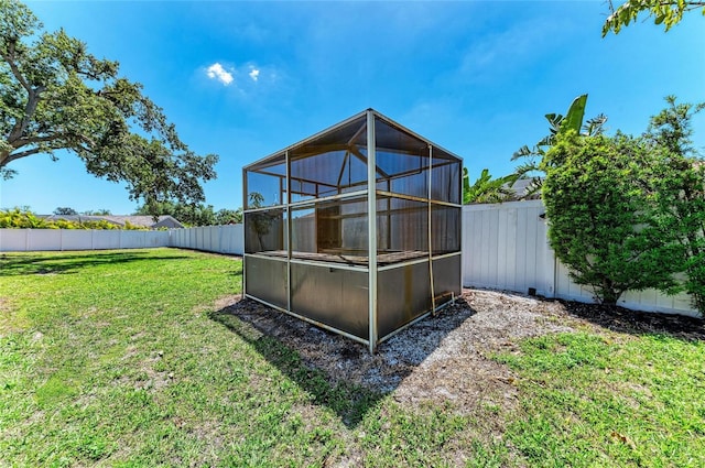 rear view of house with a lawn and a fenced backyard