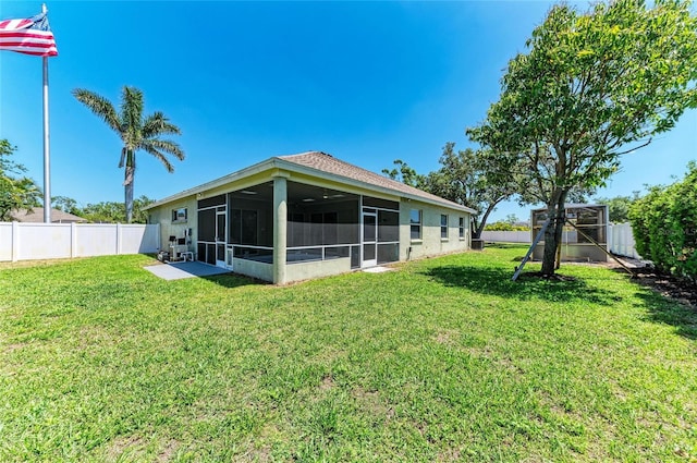 rear view of property with a sunroom, a fenced backyard, and a lawn