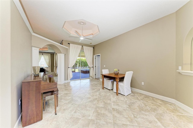dining space featuring baseboards, arched walkways, and ceiling fan