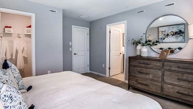 carpeted bedroom with baseboards, visible vents, and a spacious closet