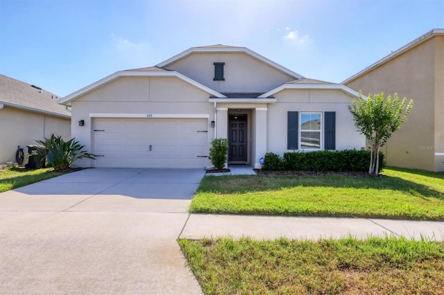 ranch-style home featuring concrete driveway, an attached garage, a front lawn, and stucco siding