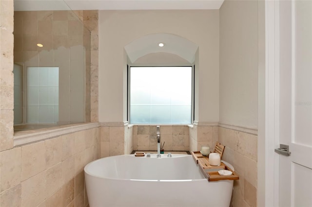 4307 Camino Real, Sarasota, FL 34231 - bathroom with tile walls, a soaking tub, and wainscoting