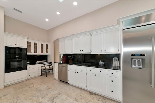 4307 Camino Real, Sarasota, FL 34231 - kitchen with black appliances, a sink, decorative backsplash, white cabinets, and dark countertops