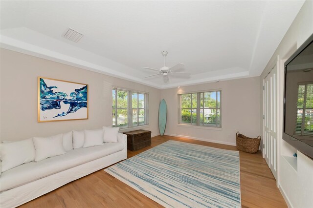 4307 Camino Real, Sarasota, FL 34231 - living room featuring a tray ceiling, light wood-style floors, plenty of natural light, and ceiling fan