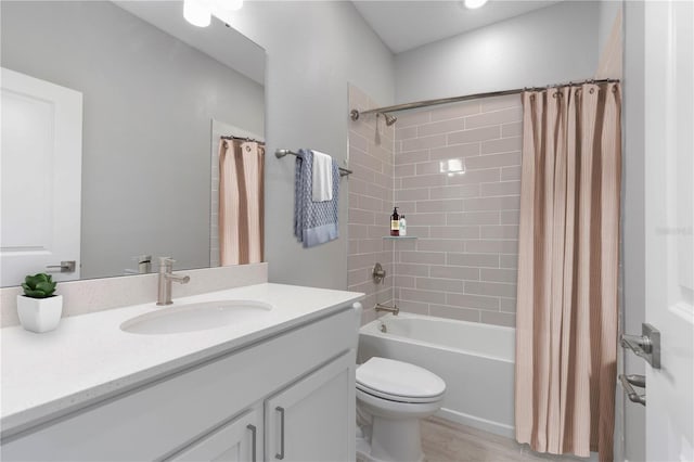 bathroom with vanity, toilet, wood finished floors, and shower / tub combo with curtain