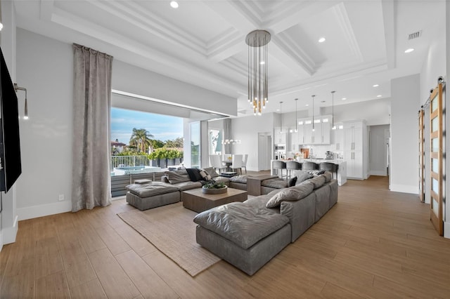 living room featuring a barn door, coffered ceiling, light wood finished floors, and beamed ceiling