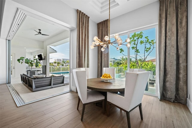 dining area with ceiling fan with notable chandelier and wood finished floors