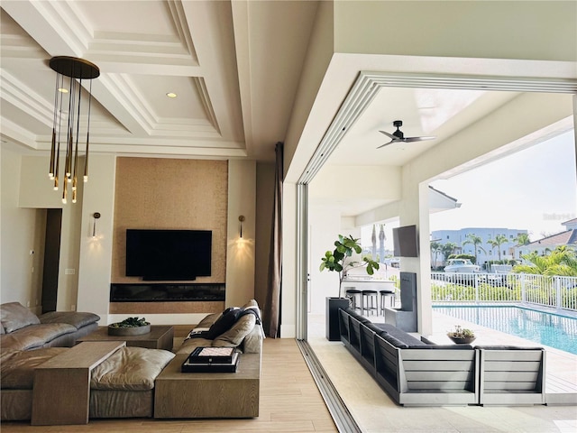 living area featuring crown molding, light wood-style flooring, a ceiling fan, beamed ceiling, and coffered ceiling