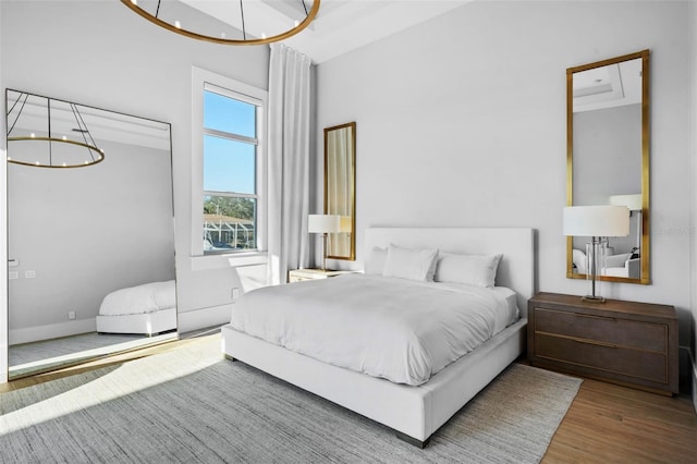 bedroom featuring a notable chandelier and wood finished floors