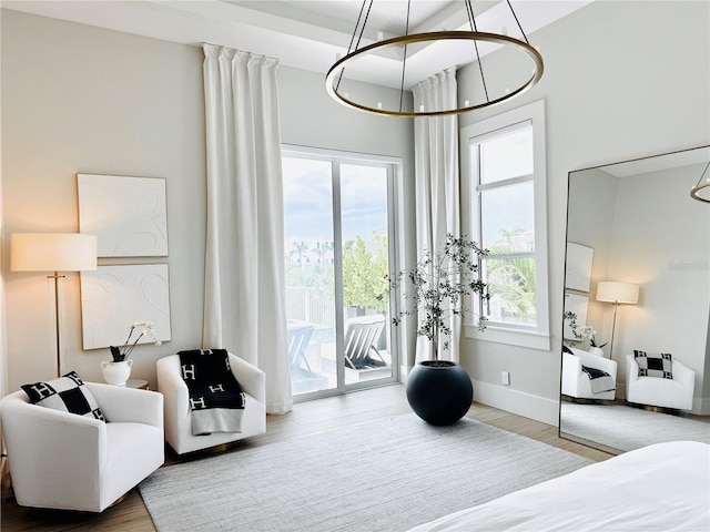 bedroom with baseboards, a chandelier, access to exterior, and wood finished floors