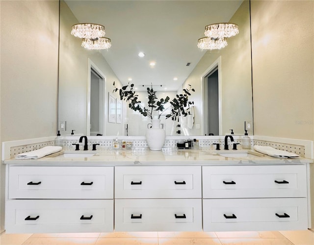 bathroom with an inviting chandelier, a sink, and double vanity