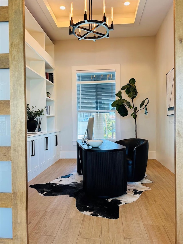 office with recessed lighting, a tray ceiling, a notable chandelier, and light wood-style flooring