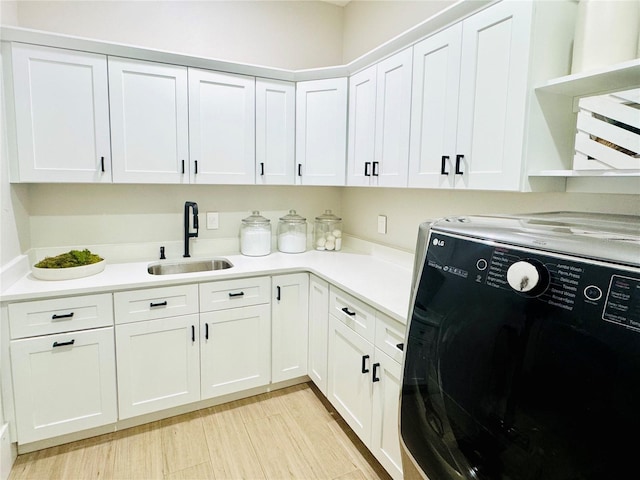 laundry area with cabinet space and a sink