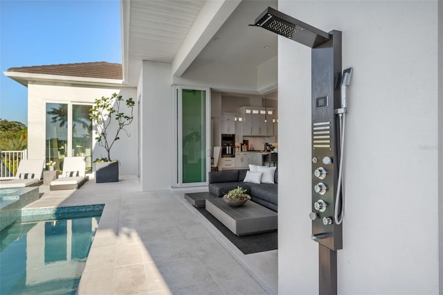 exterior space with a patio, outdoor lounge area, an outdoor pool, and stucco siding