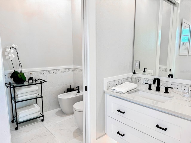1643 Stanford Ln, Sarasota, FL 34231 - bathroom featuring a bidet, vanity, tile walls, a wainscoted wall, and marble look tile flooring