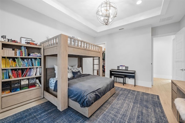 1643 Stanford Ln, Sarasota, FL 34231 - bedroom featuring wood finished floors, a chandelier, and a raised ceiling