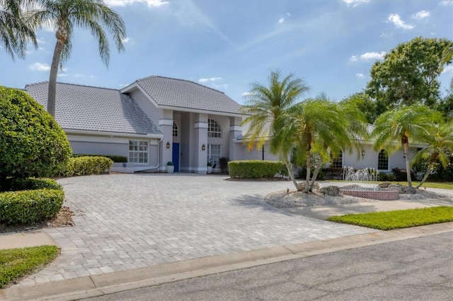 view of front of house featuring stucco siding, driveway, and a tile roof