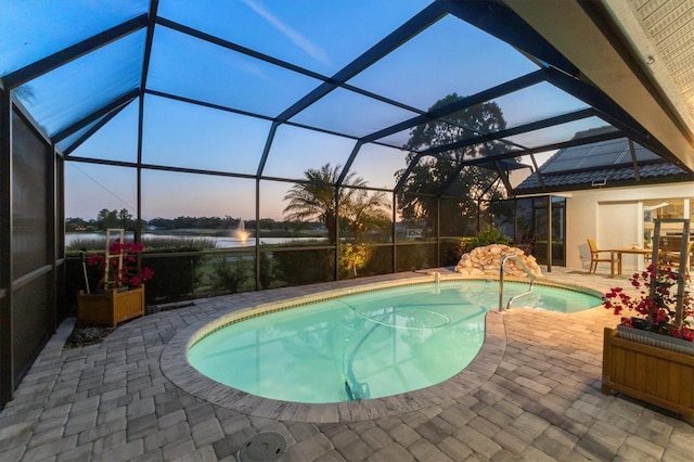 pool with a water view, a patio area, and a lanai
