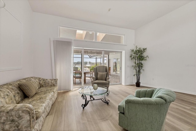 living area with baseboards and wood finished floors