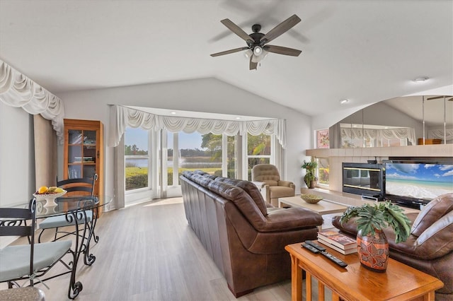 living area featuring light wood-style floors, ceiling fan, and vaulted ceiling