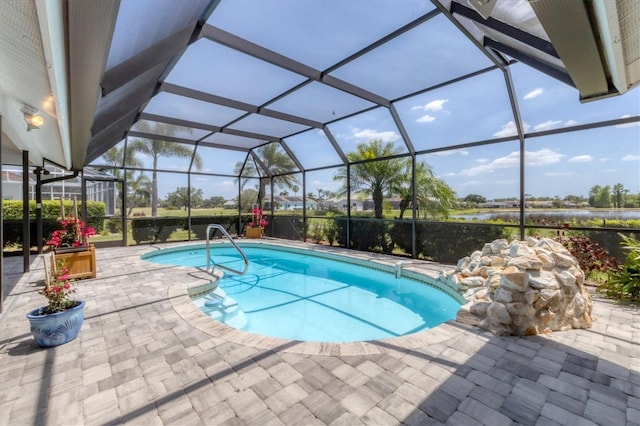 outdoor pool featuring a patio, a water view, and glass enclosure